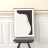 a grey chair with an art print standing on it