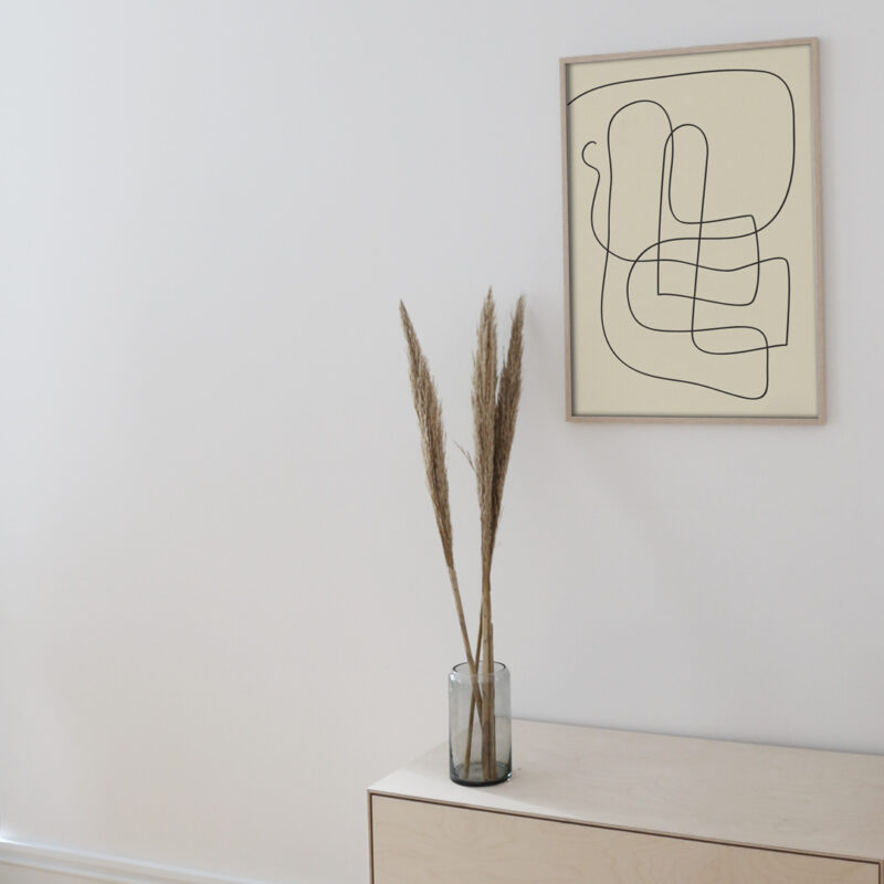 The Pen 04 art print inside a thin oak frame hanging on a white wall