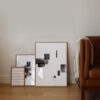 three oak frames standing on the floor with the Selected Blacks series of art prints