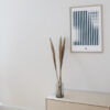 a thin oak frame hanging on a white wall with the art print inside with the title; Echo 01