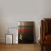 The art print with the title; Dusk 02 in an oak frame standing on the floor next to lether couch